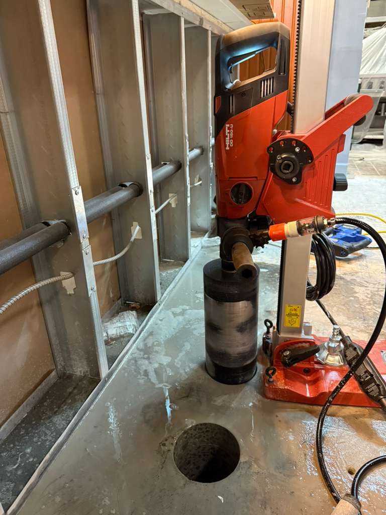 Technician performing concrete coring with professional equipment